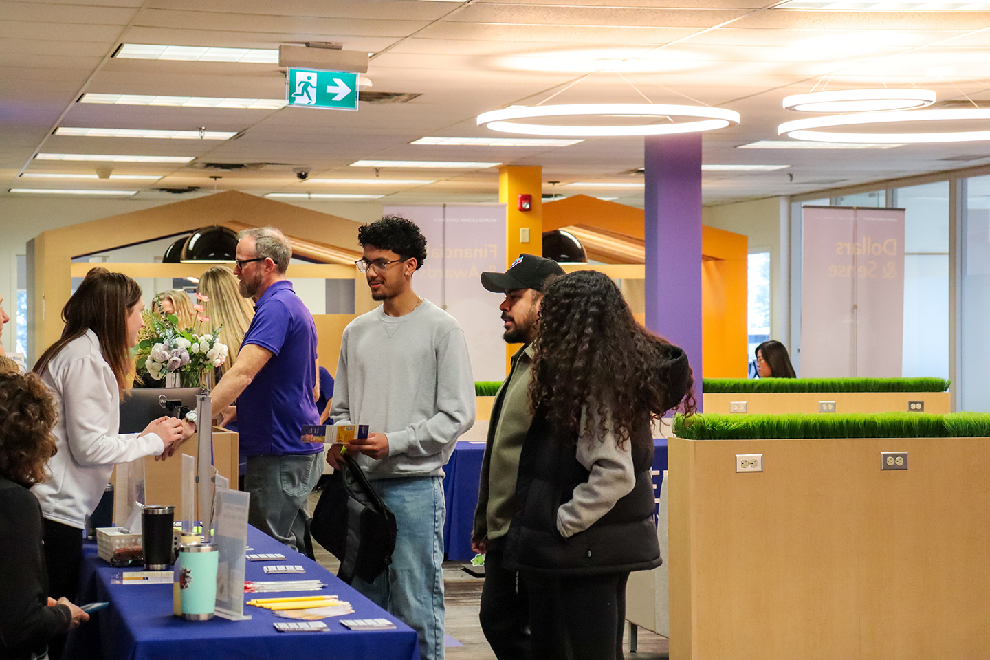Students speaking with volunteers at a table