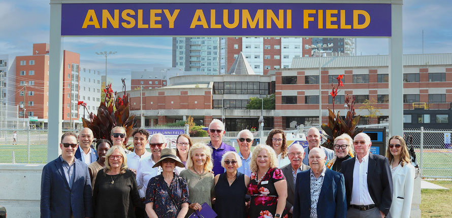 celebrating the opening of Ansley field with a group photo under sign
