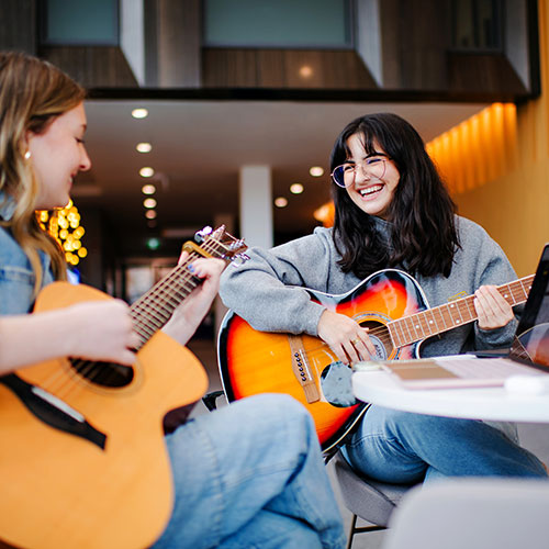 students practice guitar