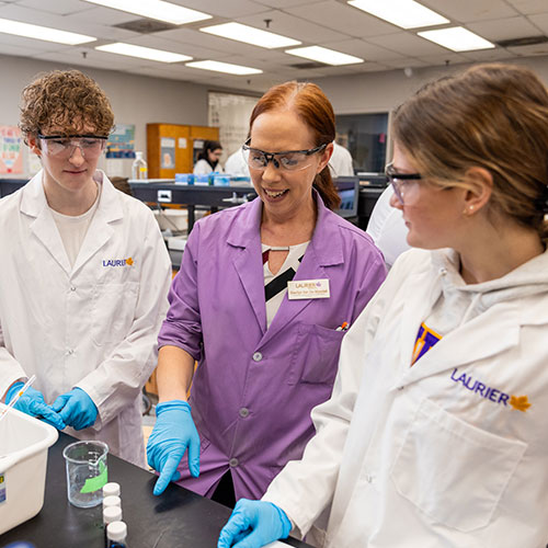 Lab coordinator working with two students