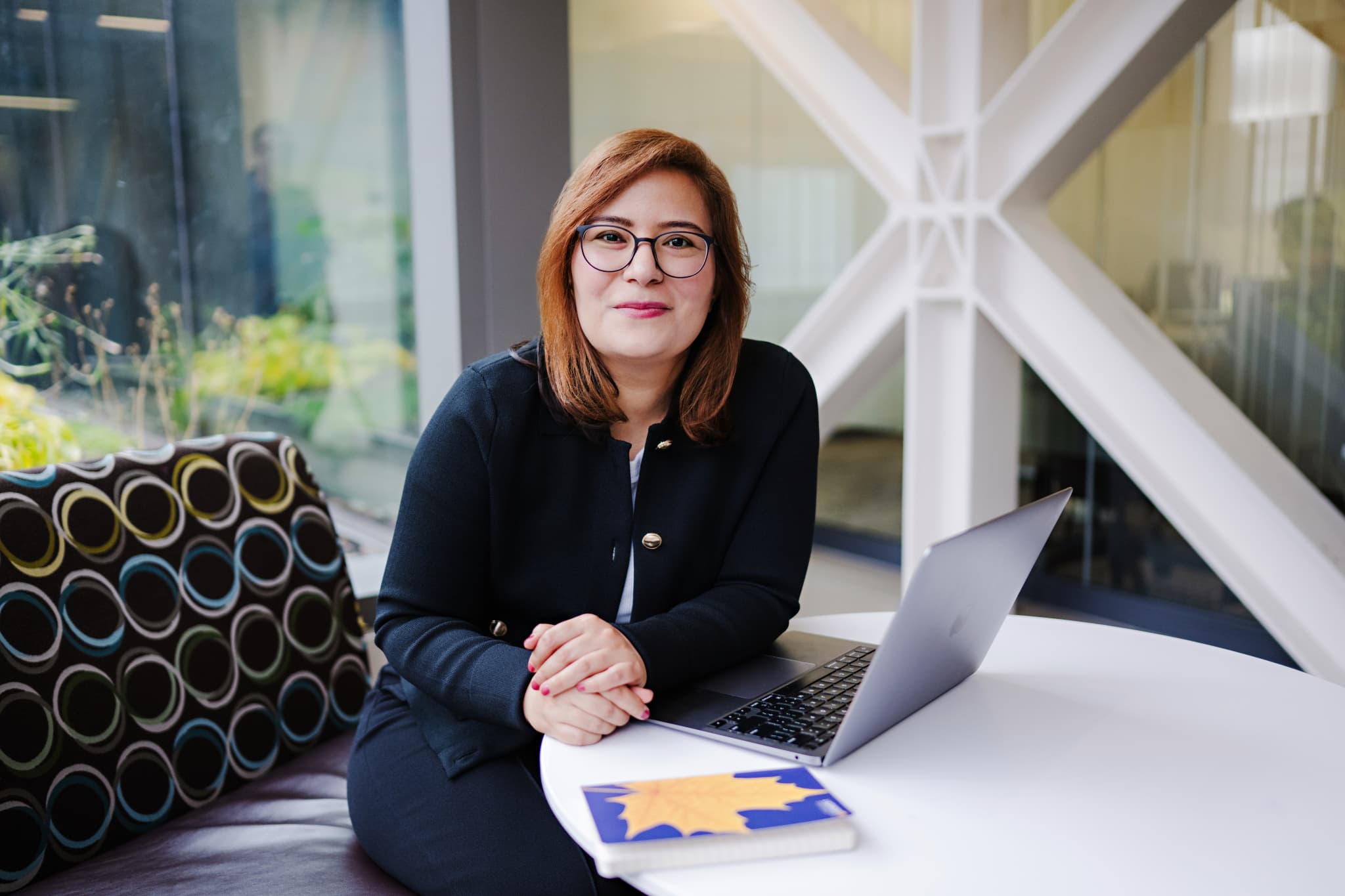 Female PhD student sitting at table with laptop