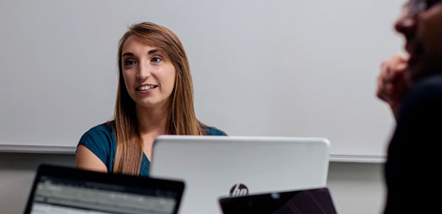 Student sitting in class with laptop