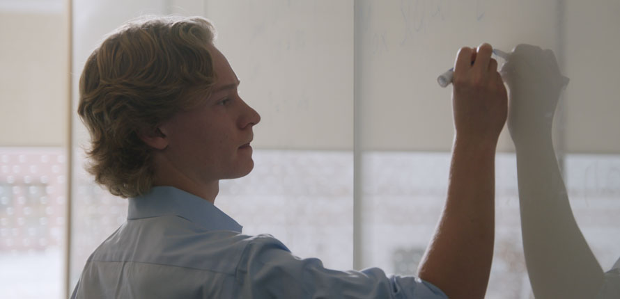 Student writing on whiteboard