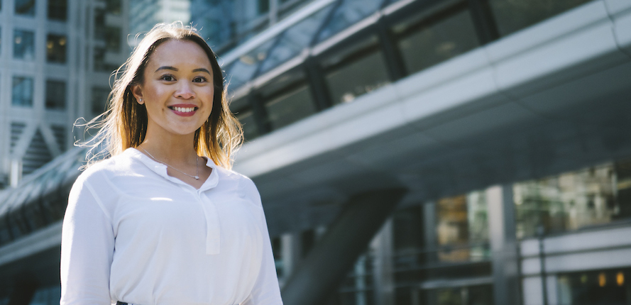 Student standing in front of a large class building