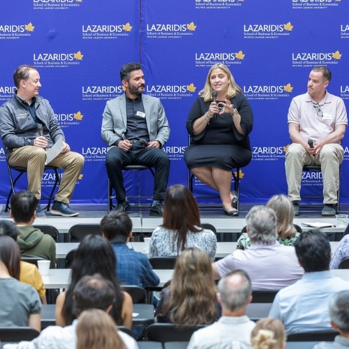 Audience listening to research chair speakers on stage