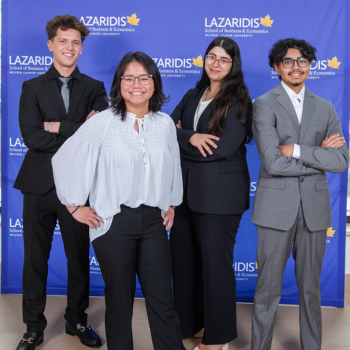 Five students pose with arms folded in front of them.
