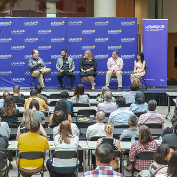 5 researchers sit on a stage in a panel discussion