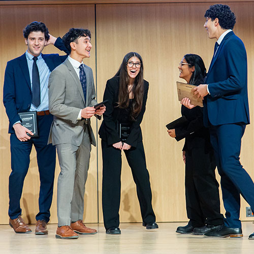 students on stage after a presentation
