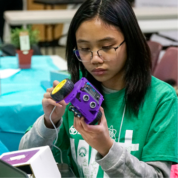 young female assembling an InkSmith robot