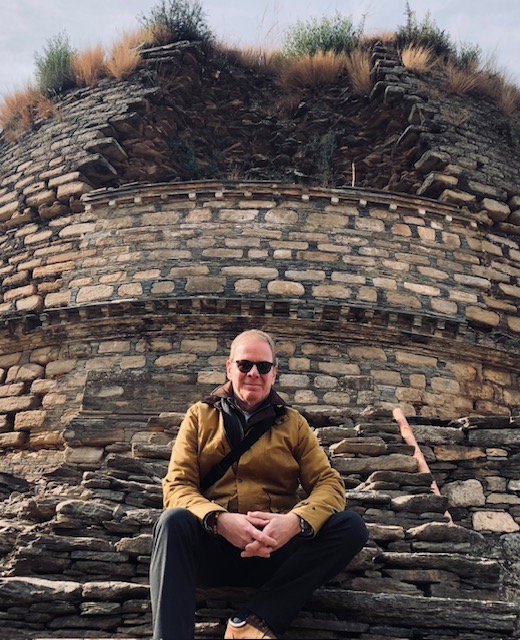 Chris Wilvert sits in front of a stone bunker.