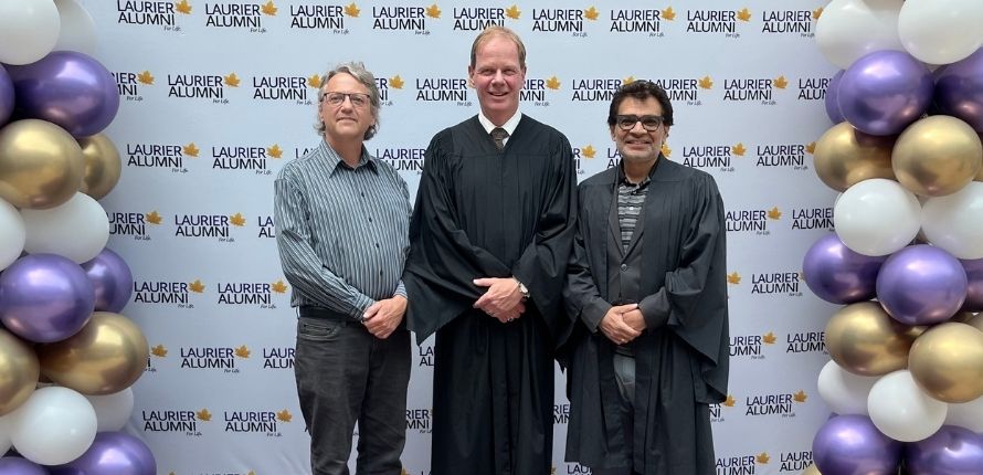 Three men standing together.