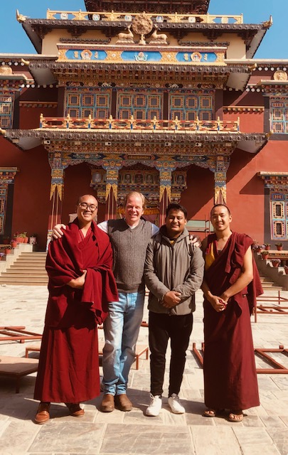 Two men standing with two monks.