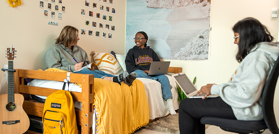 Students sitting on a bed studying