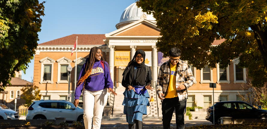 three students walking on Brantford campus in fall