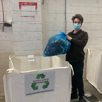 Man holding bag of items for recycling.