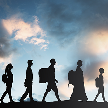 Refugees walking against skyline