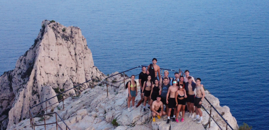 students pose on a rocky outcropping