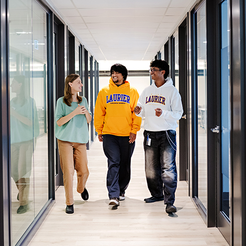 Staff member and students in hallway
