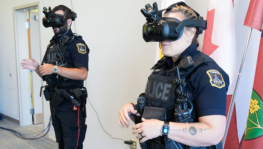 Two police officers wearing virtual reality headsets