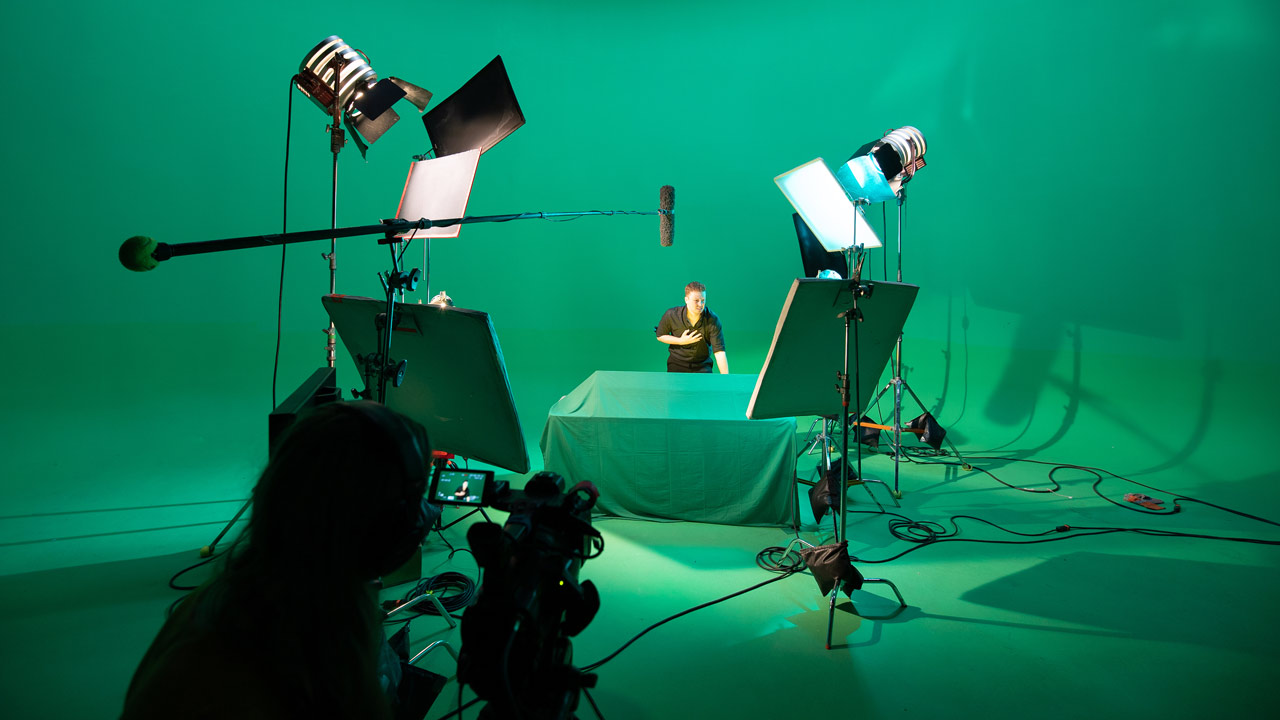 student on set with green screen background