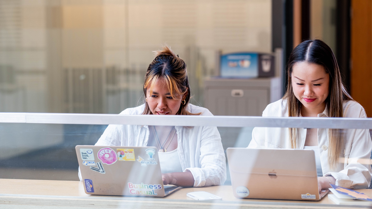 two female students on laptops