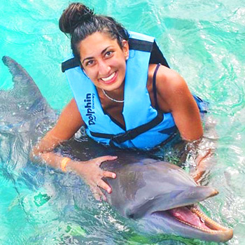 student posing with dolphin