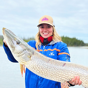 blonde student holding fish in the outdoors