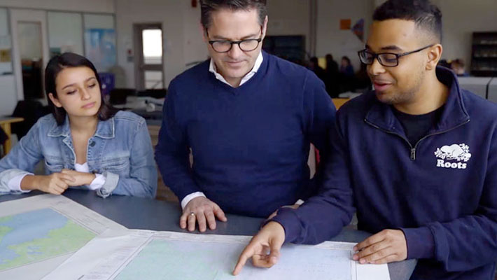 students look at map with professor